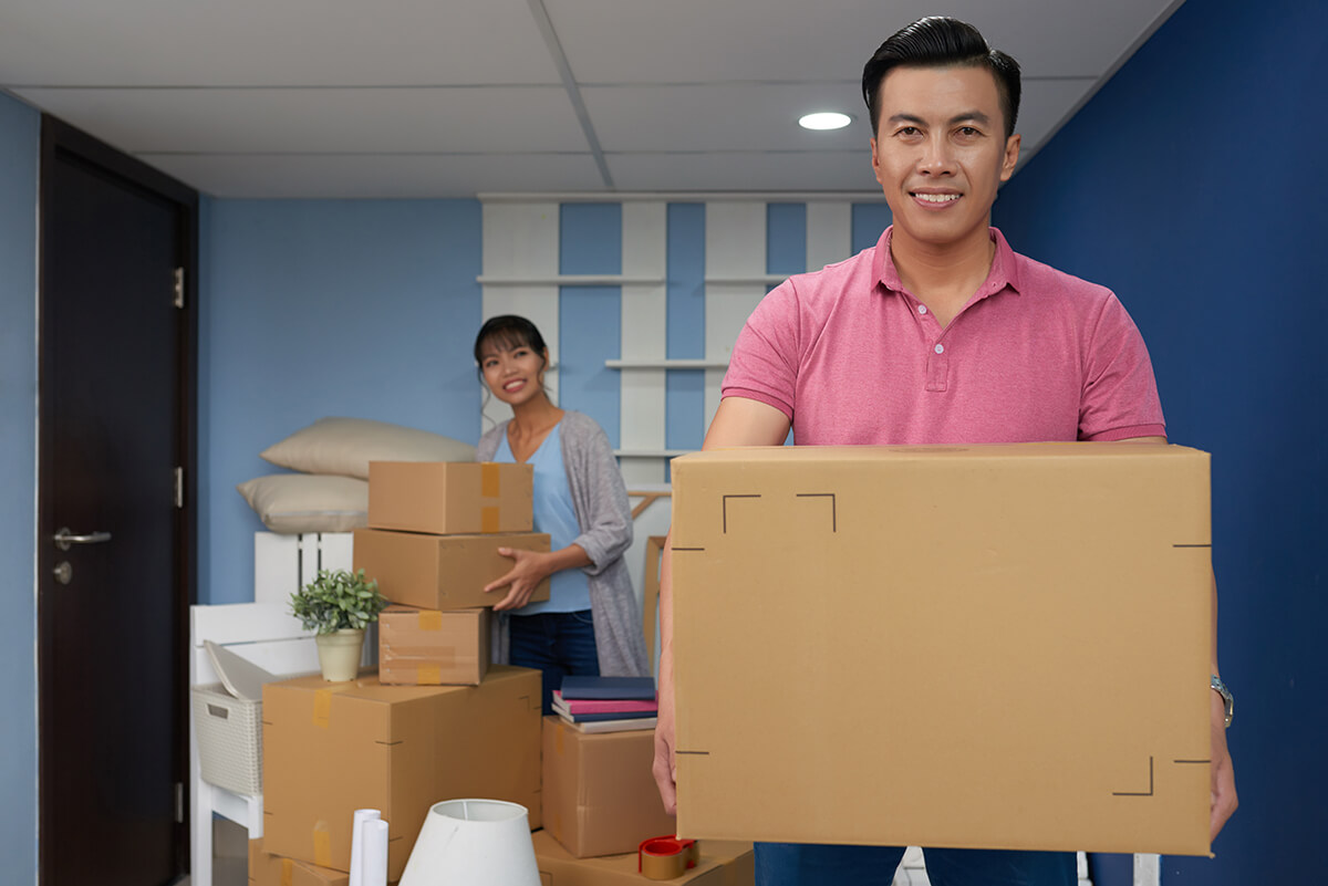Asian man holding cardboard box