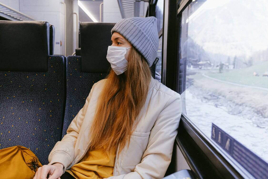 A woman wearing a mask in a train