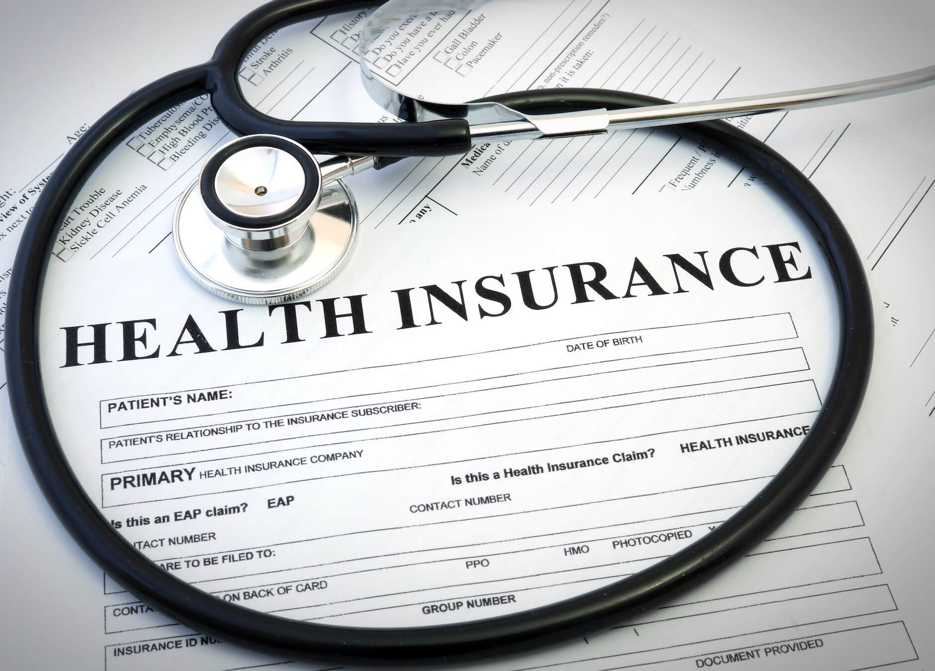 A close-up of a health insurance application and a stethoscope
