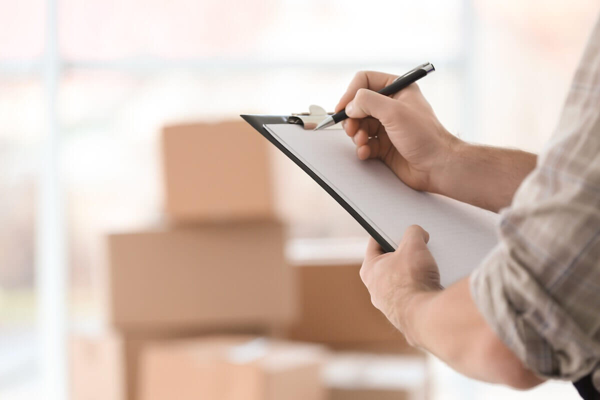 A man writing down his relocating abroad checklist to stay organized.