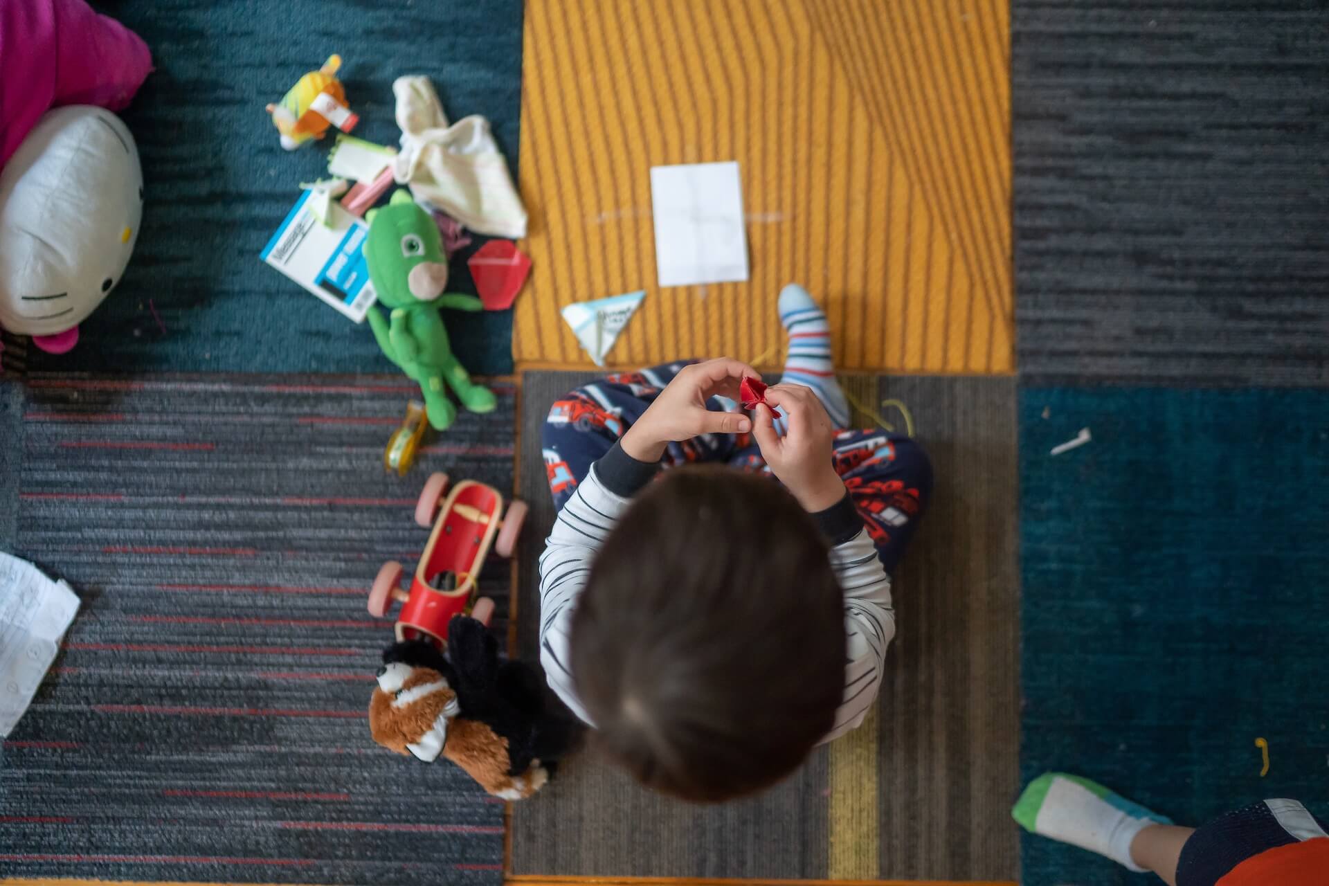 Top view photo of a toddler playing with toys