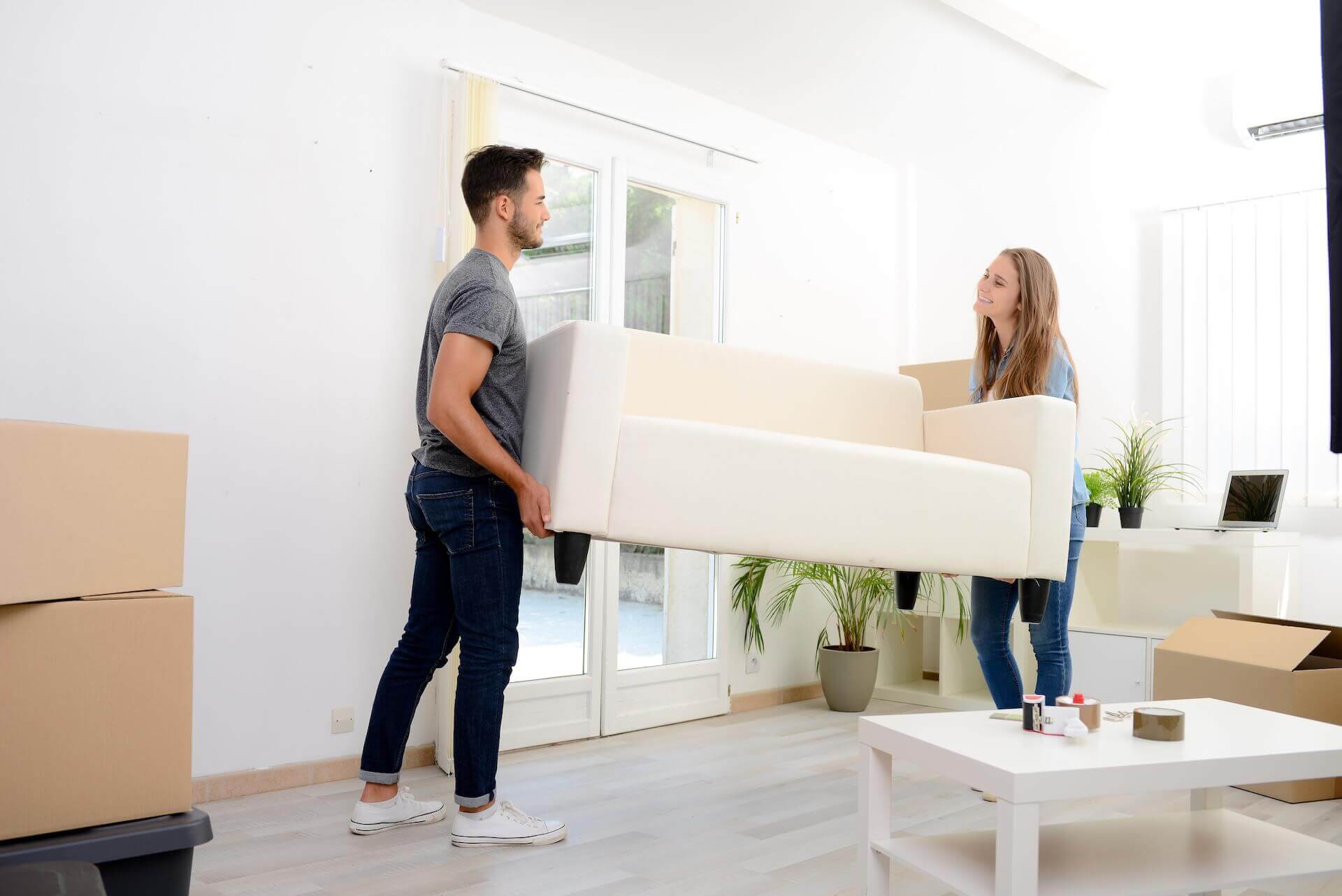 Two people carrying a couch