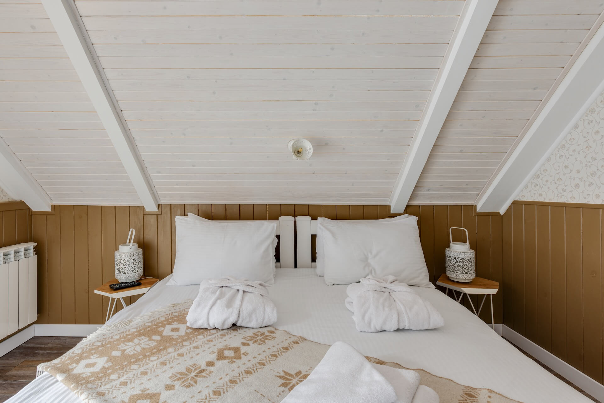 Wooden bed with white linen and pillows
