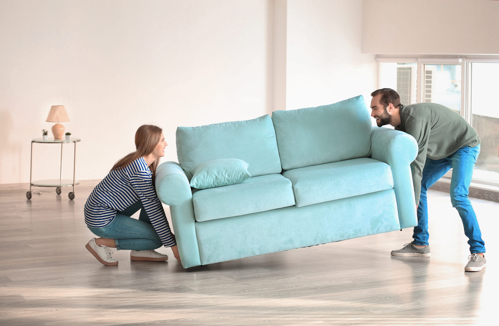 A couple lifting a sofa before moving internationally