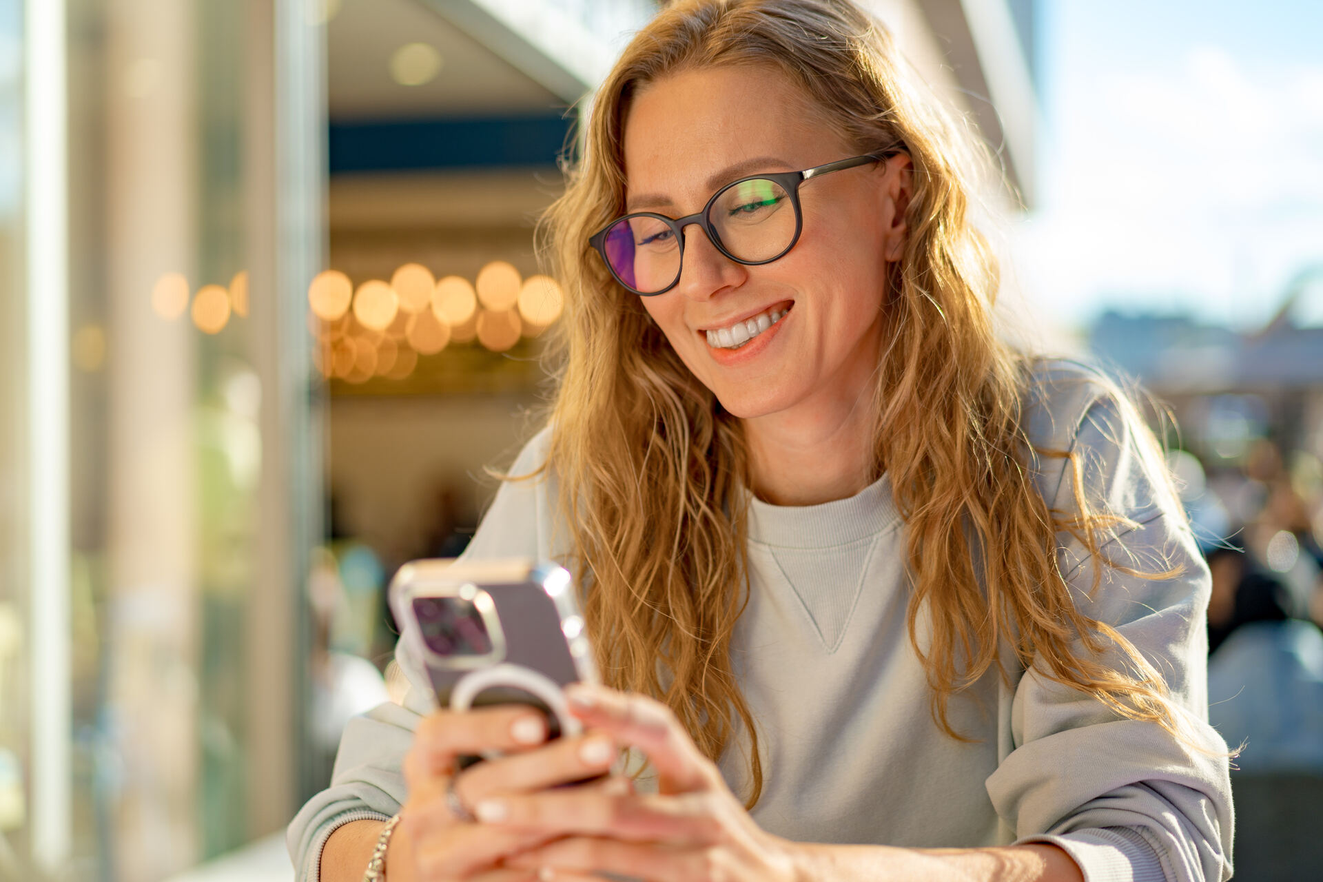 A woman smiling and using a phone