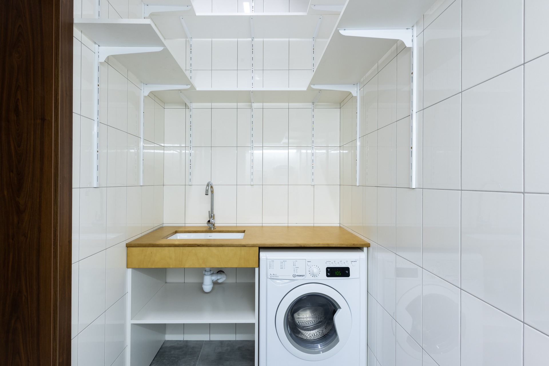 An empty laundry area with a washer