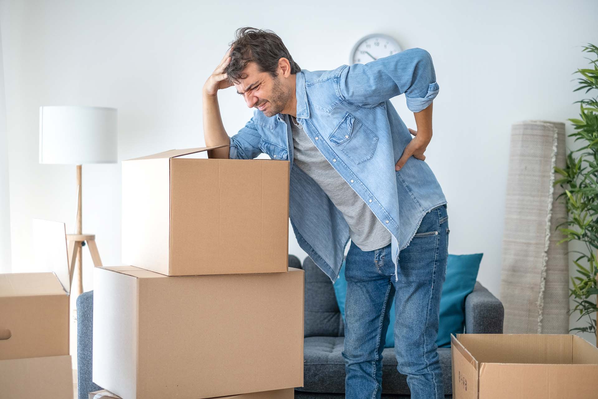Man lifting boxes and moving into new house suffers backache