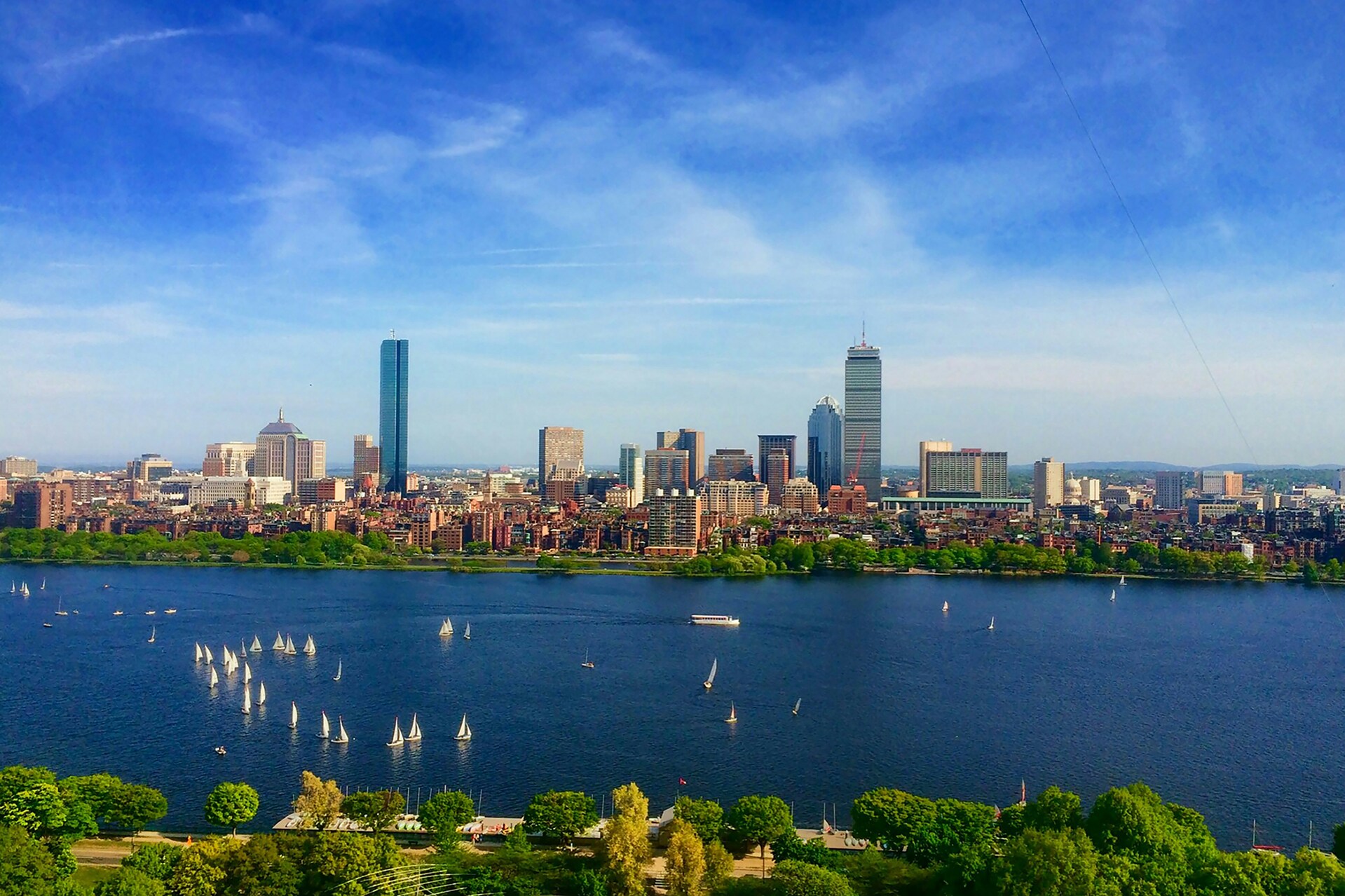 A stunning daytime view of a coastal city skyline featuring modern skyscrapers right next to a body of water.