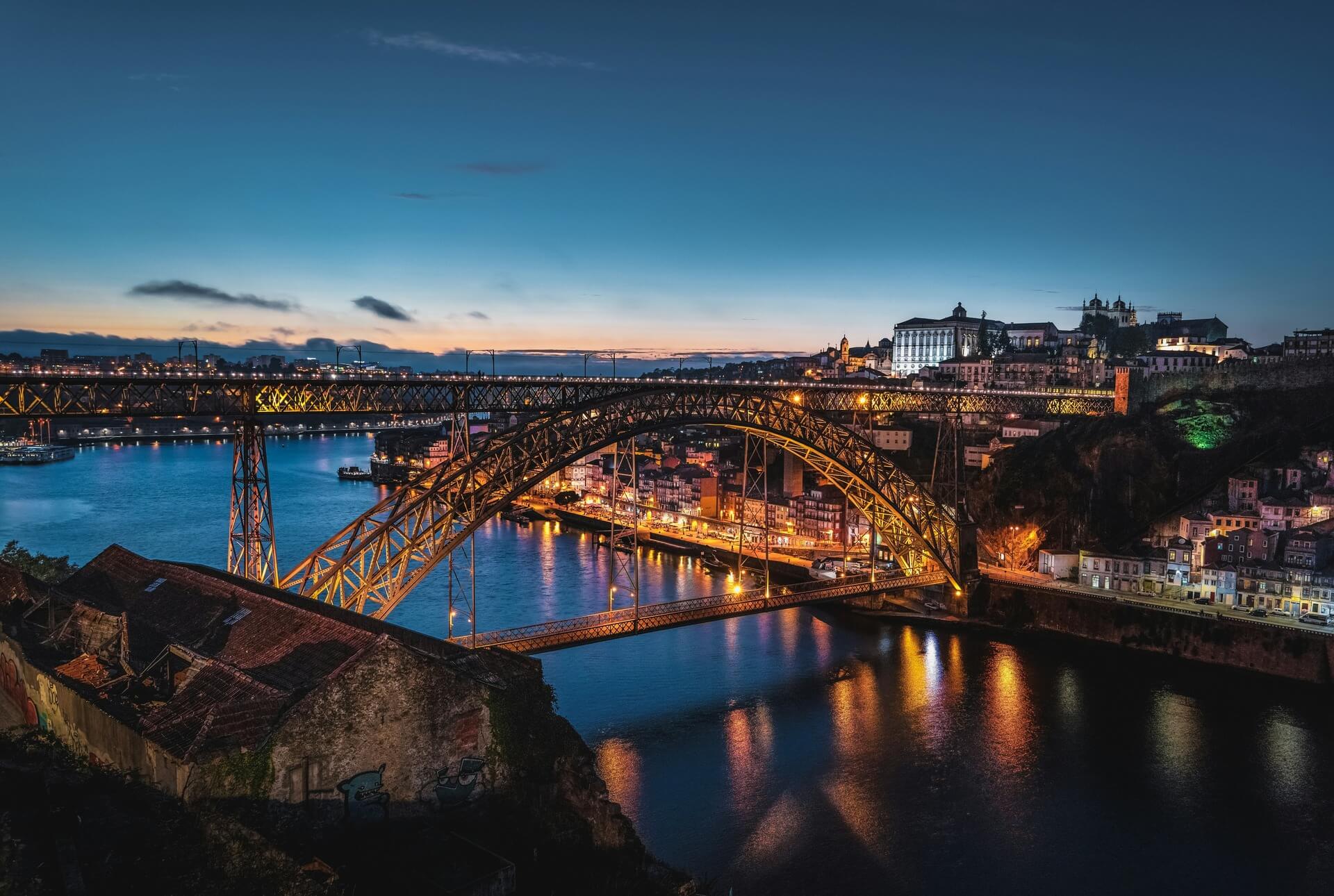 The distinctive illuminated steel arch structure of the Dom Luís I Bridge in Porto, Portugal