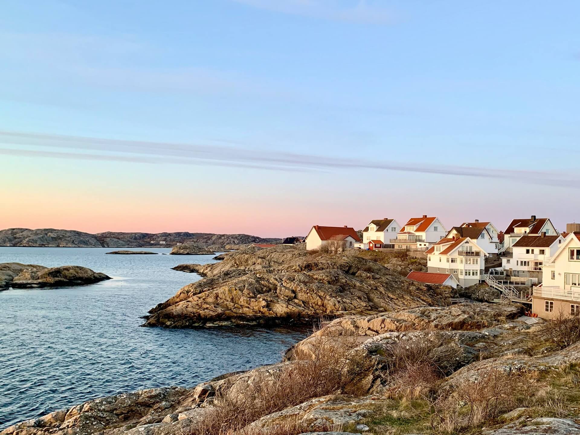 Waterfront houses and residential buildings located near a calm body of water during daytime.